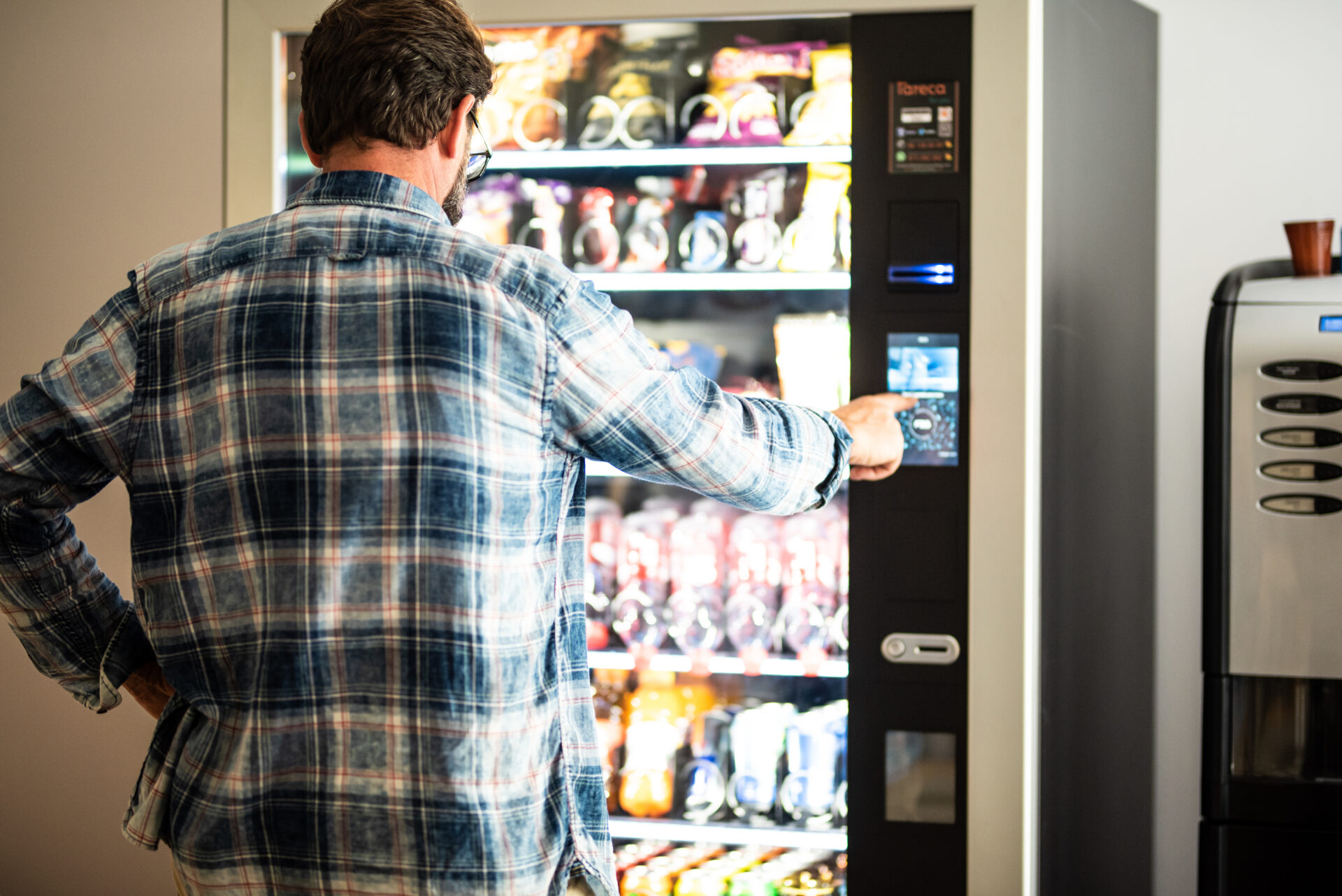 Man using vending machine touchscreen.